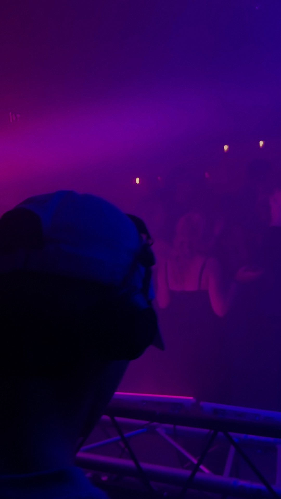 Blick über die tanzende Menge im violetten Licht