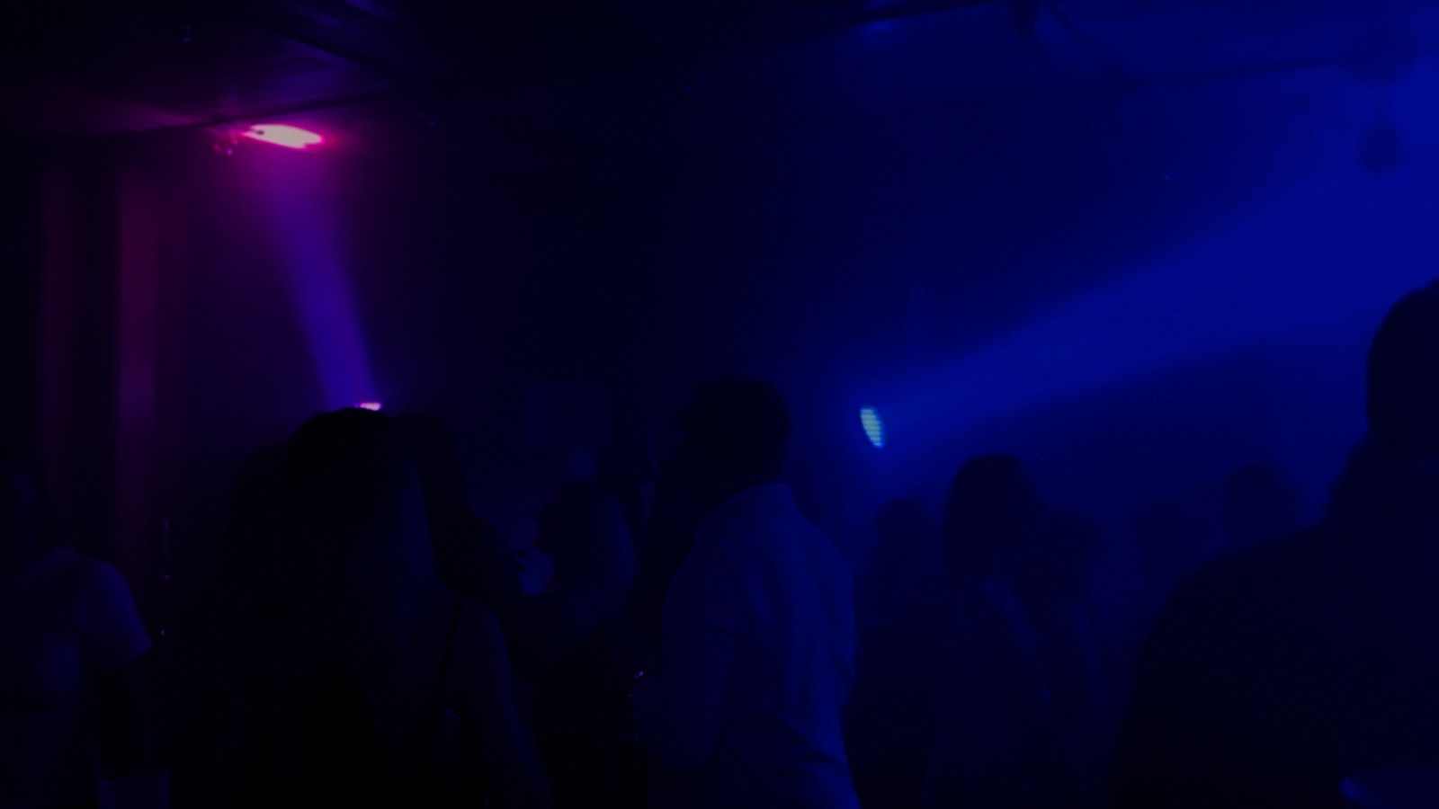 Tanzfläche mit pinkem Lichtstrahl und Nebel